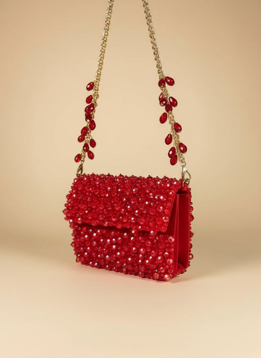 Red beaded handbag with gold chain on a white background clutch saree clutch